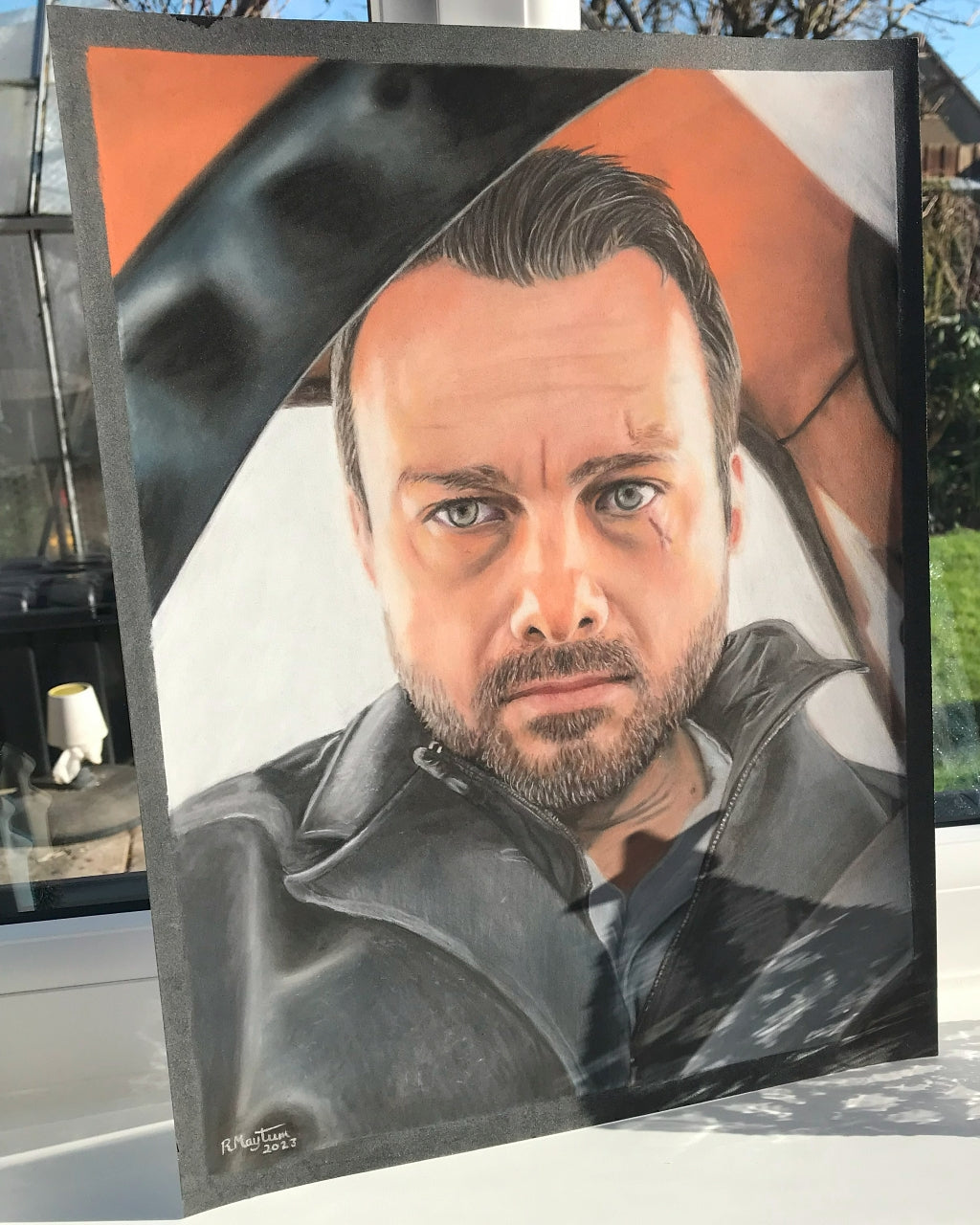 Hand-drawn pastel portrait of a man in a black jacket, with a neutral expression, realism style, displayed on a window sill!