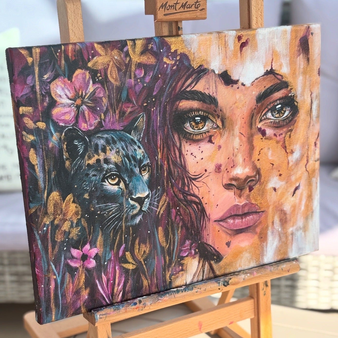 Painting of a woman's face and panther on an easel with 'Mont Marte' branding.