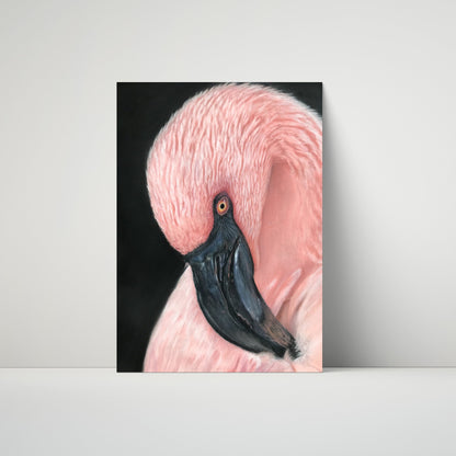 A vertical art print depicting a close-up portrait of a pink flamingo with a black beak against a dark background, leaning against a light gray wall on a white surface.